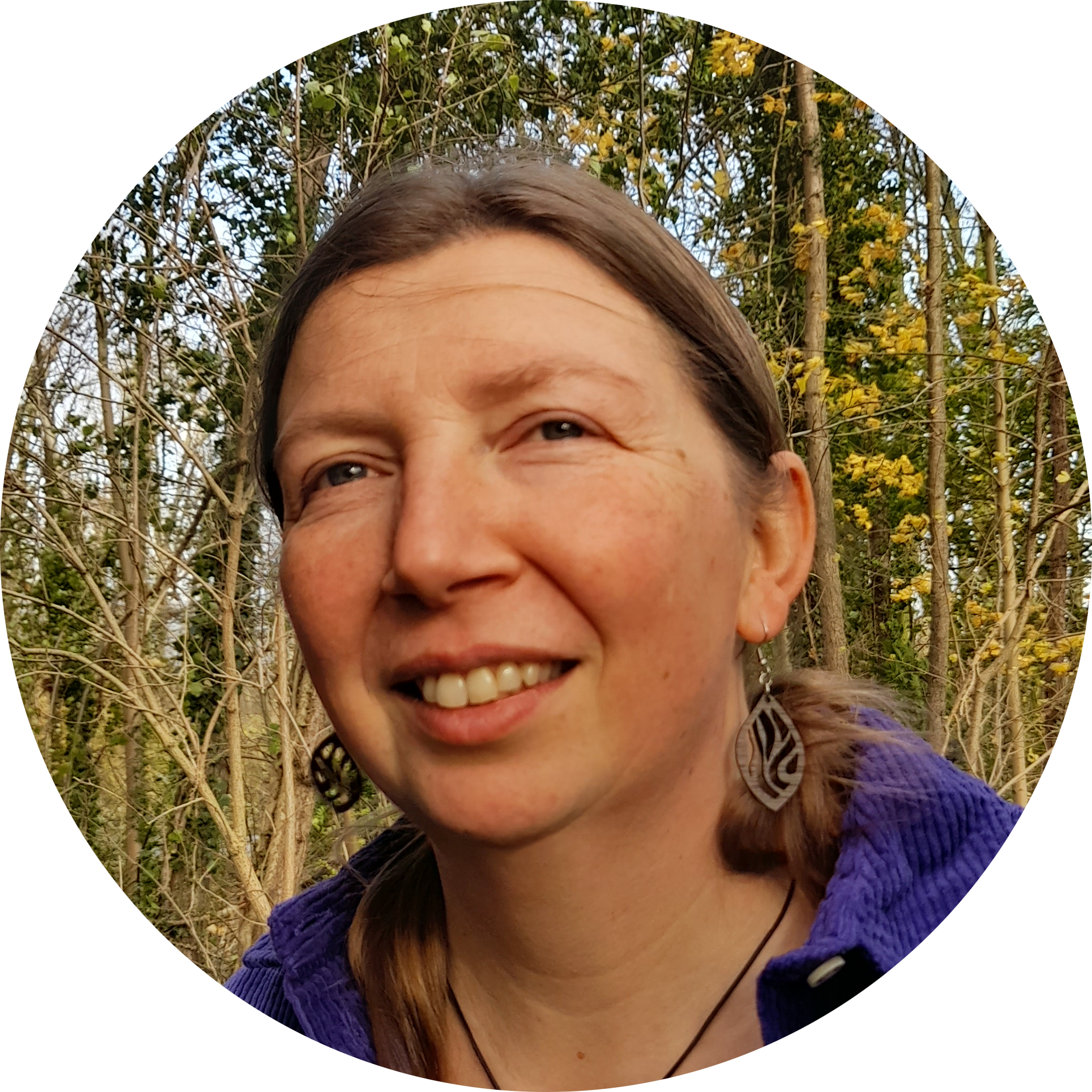 Linda's portret. Op de achtergrond zie je allerlei groentinten enzovoort. De foto is genomen in een bos.